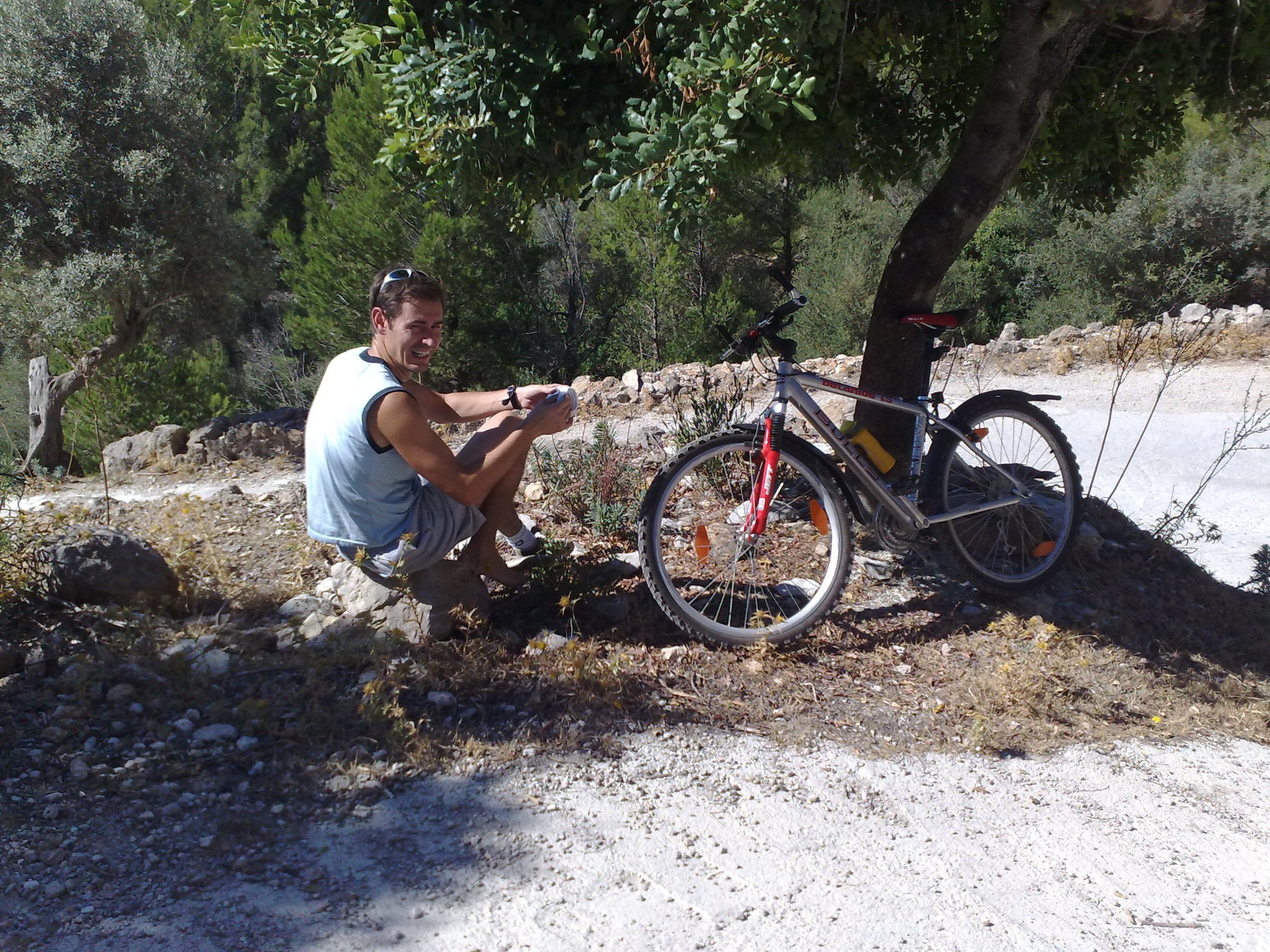 Claudio descansa junto a su bicicleta después de una caída en la montaña