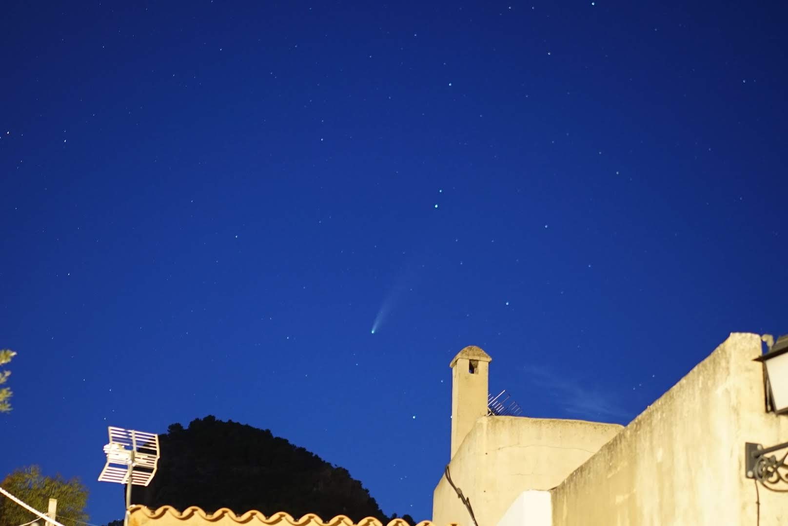 Cometa sobre los tejados de Alaró bajo un cielo estrellado