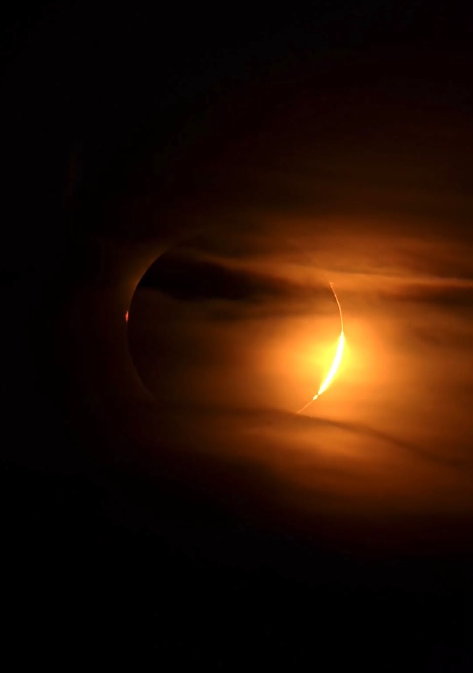 Eclipse parcial entre nubes anaranjadas