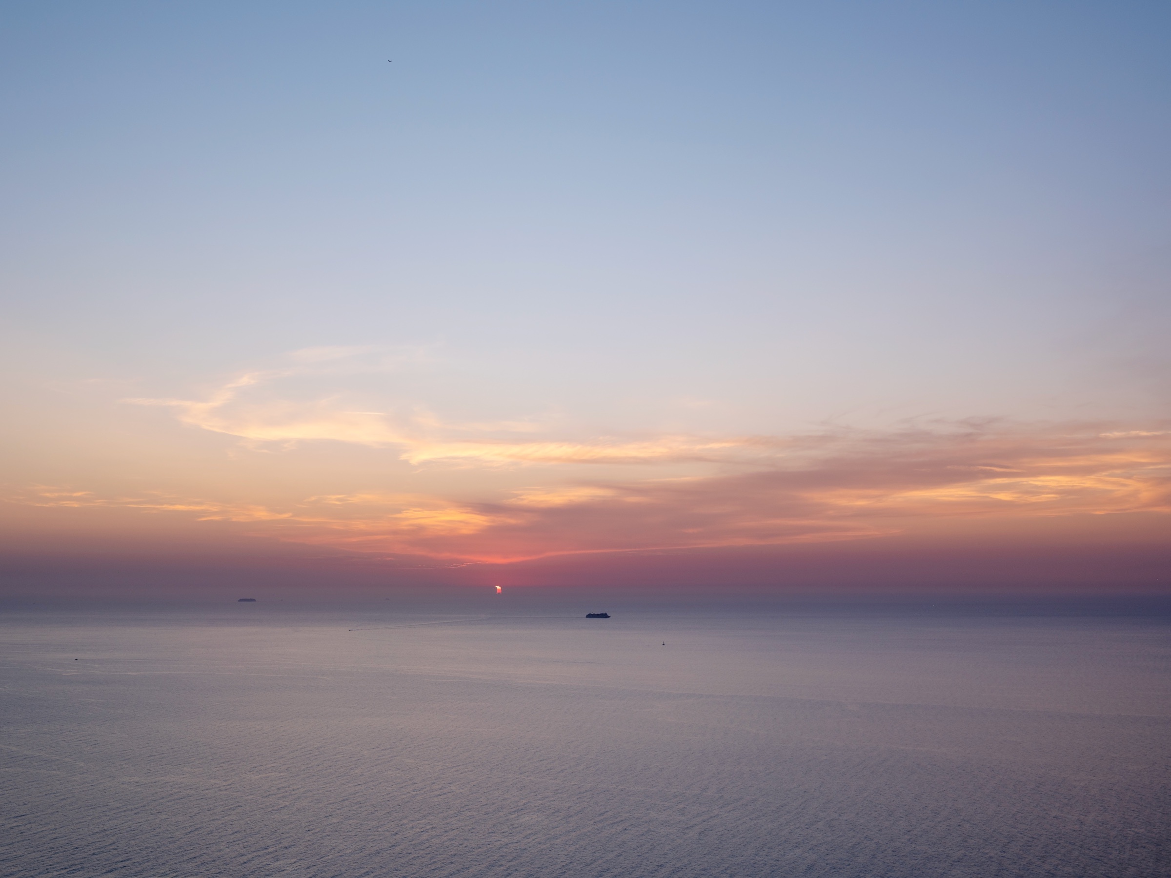 Eclipse parcial junto al horizonte sobre el mar